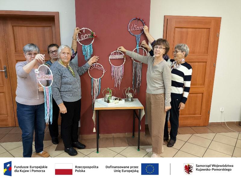 zdjęcie seniorów, trzymających zawieszki dekoracyjne